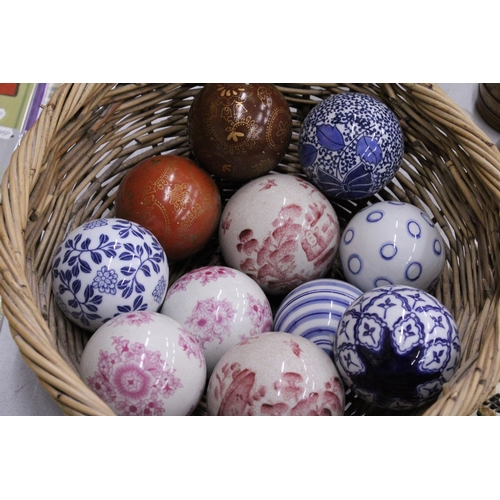 278 - A COLLECTION OF VARIOUS SIZES OF PATTERNED CERAMIC BALLS IN A BASKET