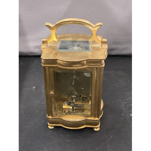 32 - A BRASS CARRIAGE CLOCK WITH WHITE ENAMEL FACE, ROMAN NUMERALS AND VISUAL ESCAPEMENT