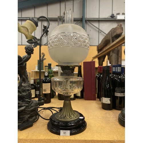 61 - A VICTORIAN OIL LAMP WITH MILKY GLASS SHADE AND GLASS RESERVOIR ON A BRASS COLUMN AND BLACK PLINTH