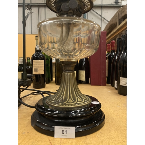 61 - A VICTORIAN OIL LAMP WITH MILKY GLASS SHADE AND GLASS RESERVOIR ON A BRASS COLUMN AND BLACK PLINTH