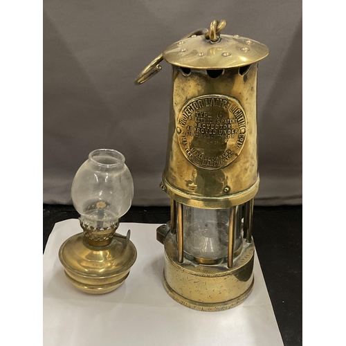 85 - TWO BRASS LAMPS TO INCLUDE A VICTORIAN MINIATURE PARAFFIN LAMP WITH GLASS FUNNEL AND A PROJECTOR LAM... 