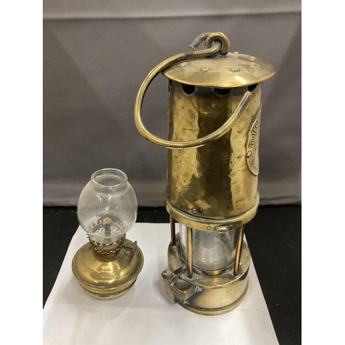 85 - TWO BRASS LAMPS TO INCLUDE A VICTORIAN MINIATURE PARAFFIN LAMP WITH GLASS FUNNEL AND A PROJECTOR LAM... 