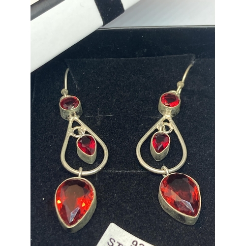 701 - A PAIR OF MARKED SILVER EARRINGS WITH GARNETS IN A PRESENTATION BOX