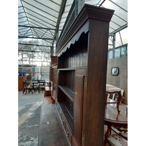 2889 - A GEORGIAN OAK DRESSER WITH THREE DRAWERS TO BASE AND PLATE RACK ENCLOSING TWO CUPBOARDS WITH H BRAS... 