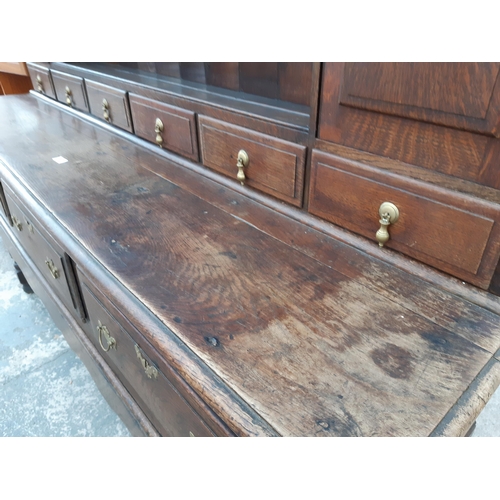 2889 - A GEORGIAN OAK DRESSER WITH THREE DRAWERS TO BASE AND PLATE RACK ENCLOSING TWO CUPBOARDS WITH H BRAS... 