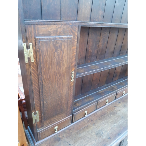 2889 - A GEORGIAN OAK DRESSER WITH THREE DRAWERS TO BASE AND PLATE RACK ENCLOSING TWO CUPBOARDS WITH H BRAS... 