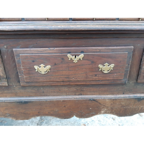 2889 - A GEORGIAN OAK DRESSER WITH THREE DRAWERS TO BASE AND PLATE RACK ENCLOSING TWO CUPBOARDS WITH H BRAS... 