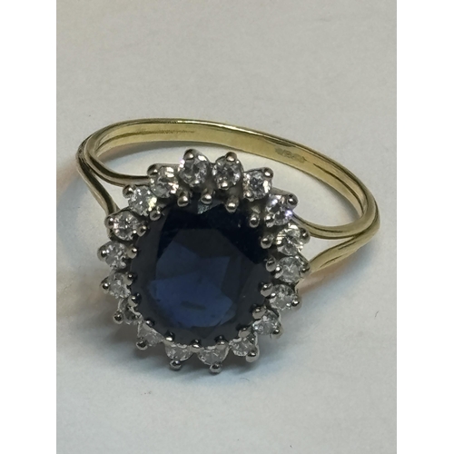 610 - AN 18 CARAT YELLOW AND WHITE GOLD RING SET WITH A SINGLE OVAL SHAPED SAPPHIRE AND EIGHTEEN ROUND BRI... 