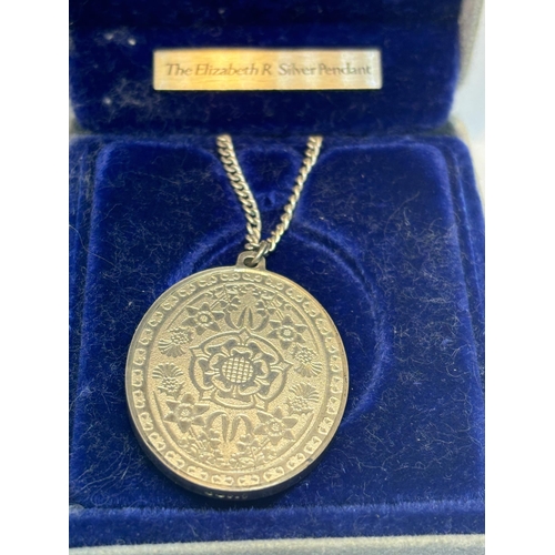 612 - A QUEEN ELIZABETH SILVER PENDANT ON A CHAIN IN A PRESENTATION BOX