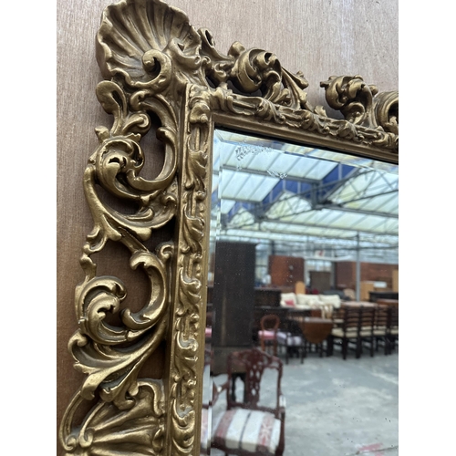 2909 - A 19TH CENTURY STYLE GILT EFFECT BEVEL EDGE WALL MIRROR WITH SCROLLED FOLIATE DECORATION, 33