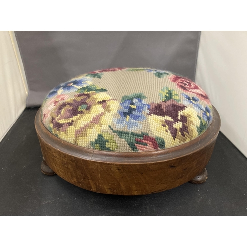 25 - A VICTORIAN TAPESTRY NEEDLEPOINT FOOTSTOOL WITH THREE BUN FEET