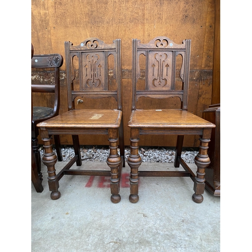 2525 - A PAIR OF 19TH CENTURY OAK HALL CHAIRS WITH TURNED FRONT LEGS AND PARTIAL FRETWORK BACK PANELS