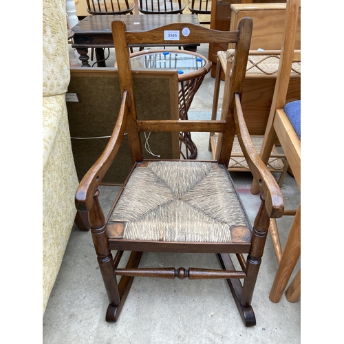 2545 - A 19TH CENTURY BEECH CHILDS ROCKING CHAIR WITH RUSH SEAT