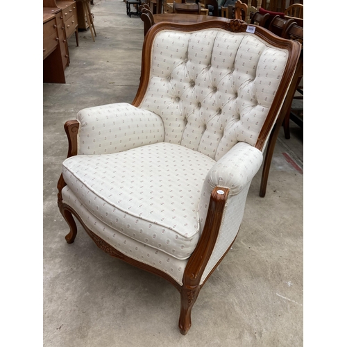 2558 - A CONTINENTAL STYLE BUTTON BACK FIRESIDE CHAIR WITH FOLIATE CARVING