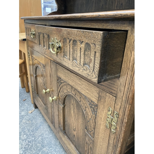 2573 - AN OAK JACOBEAN STYLE DRESSER WITH PLATE RACK, 42