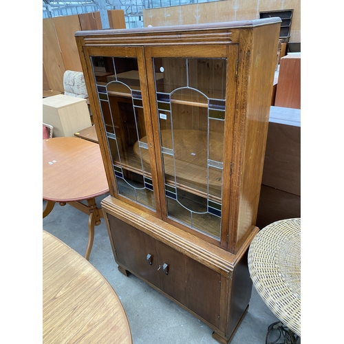 2637 - A MID 20TH CENTURY BOOKCASE WITH COLOURED GLASS AND LEADED UPPER PORTION AND CUPBOARDS TO BASE, 37