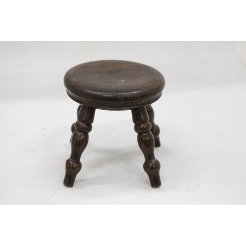 55 - A VINTAGE MINIATURE OAK FOUR LEGGED STOOL HEIGHT 12 CM TALL