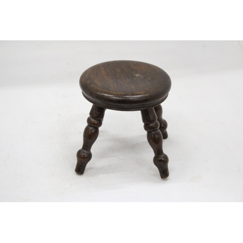 55 - A VINTAGE MINIATURE OAK FOUR LEGGED STOOL HEIGHT 12 CM TALL