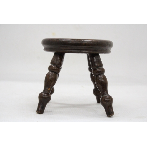 55 - A VINTAGE MINIATURE OAK FOUR LEGGED STOOL HEIGHT 12 CM TALL