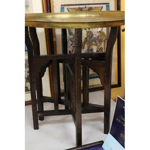 74 - A BRASS TOPPED FOLDING TABLE ON OAK LEGS