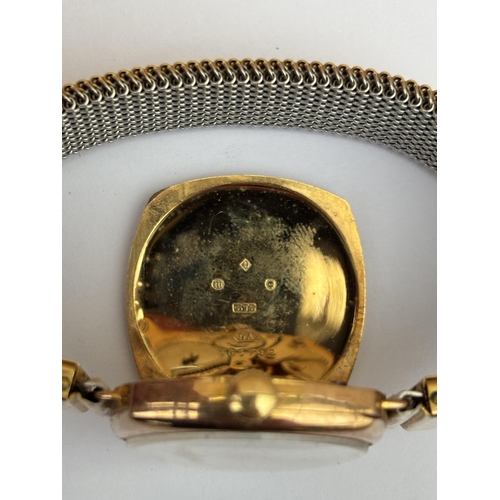 557 - A GENTS 9CT GOLD CASED EARLY 20TH CENTURY HAND WIND WRIST WATCH ON A GOLD PLATED ELASTICATED STRAP, ... 