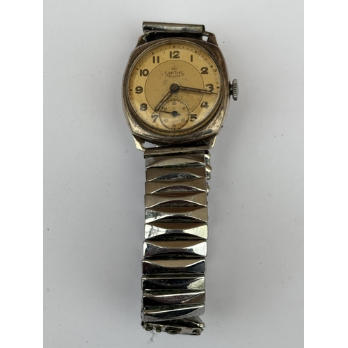 558 - A VINTAGE GENTS SMITHS DELUXE .925 SILVER CASED HAND WIND WRIST WATCH ON A ELASTICATED STRAP, (CROWN... 