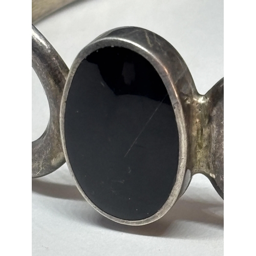 69 - A SILVER BANGLE WITH BLACK CENTRE STONE GROSS WEIGHT 26.8 GRAMS