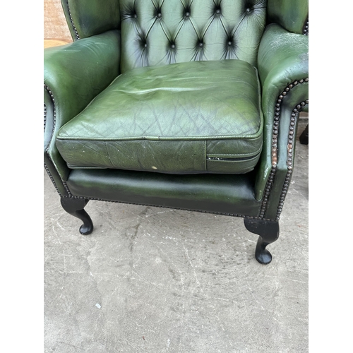 2997 - A GREEN LEATHER WINGED BUTTON BACK FIRESIDE CHAIR ON CABRIOLE LEGS