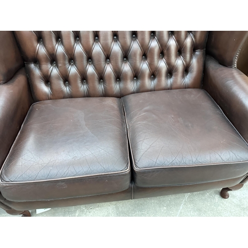 3001 - A BROWN LEATHER BUTTON BACK AND STUDDED WINGED TWO SEATER SETTEE ON CABRIOLE LEGS