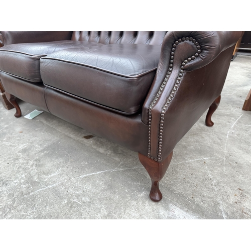 3001 - A BROWN LEATHER BUTTON BACK AND STUDDED WINGED TWO SEATER SETTEE ON CABRIOLE LEGS