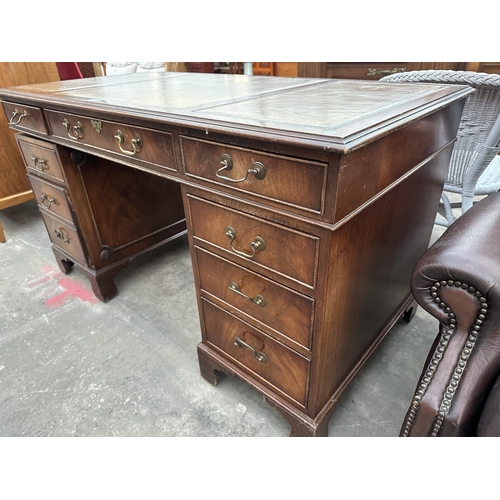 3002 - A MAHOGANY TWIN PEDESTAL DESK ENCLOSING EITGH DRAWERS WITH INSET LEATHER TOP 54