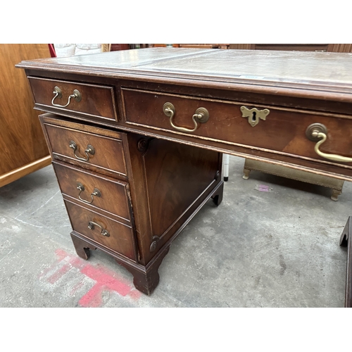 3002 - A MAHOGANY TWIN PEDESTAL DESK ENCLOSING EITGH DRAWERS WITH INSET LEATHER TOP 54