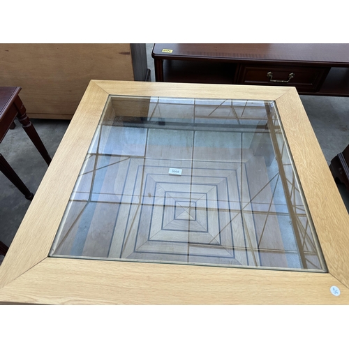 3008 - AN OAK COFFEE TABLE WITH INSET GLASS TOP AND GEOMETRIC DESIGN UNDER TIER 33.5