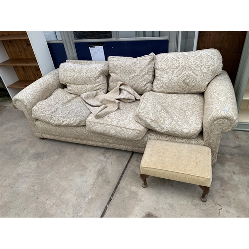 3037 - A THREE SEATER FLORAL SETTEE AND FOOTSTOOL ON CABRIOLE LEGS