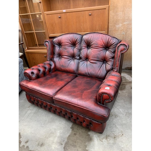 3060 - AN OXBLOOD TWO SEATER SETTEE.