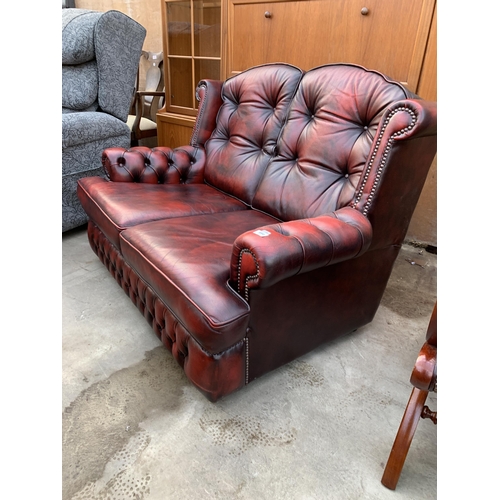 3060 - AN OXBLOOD TWO SEATER SETTEE.