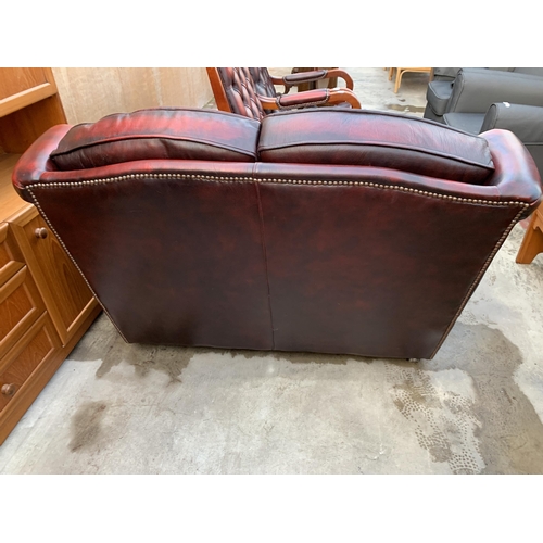 3060 - AN OXBLOOD TWO SEATER SETTEE.