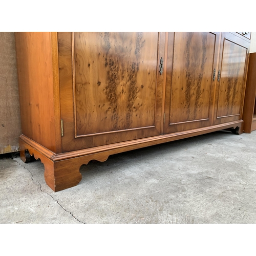 3070 - A YEW WOOD THREE DOOR GLAZED BOOKCASE ON BASE. 59