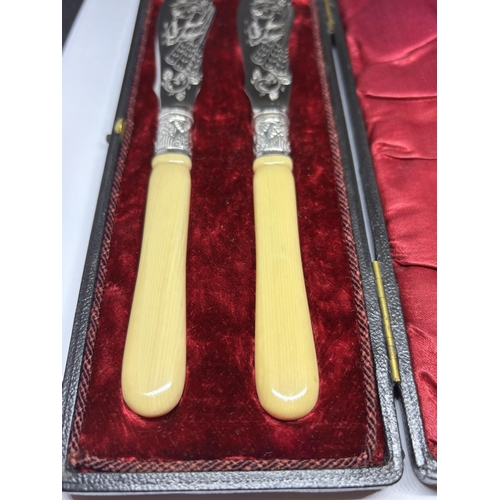 120A - A PAIR OF SILVER PLATED KNIVES IN A PRESENTATION BOX