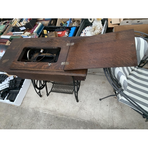 2126 - A VINTAGE JONES TREADLE SEWING MACHINE WITH CAST IRON BASE AND CABINETY