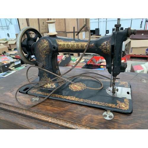 2126 - A VINTAGE JONES TREADLE SEWING MACHINE WITH CAST IRON BASE AND CABINETY