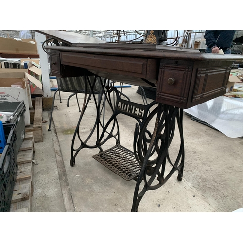 2126 - A VINTAGE JONES TREADLE SEWING MACHINE WITH CAST IRON BASE AND CABINETY