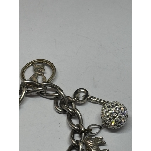 539 - A SILVER CHARM BRACELET WITH TEN CHARMS AND A HEART PADLOCK