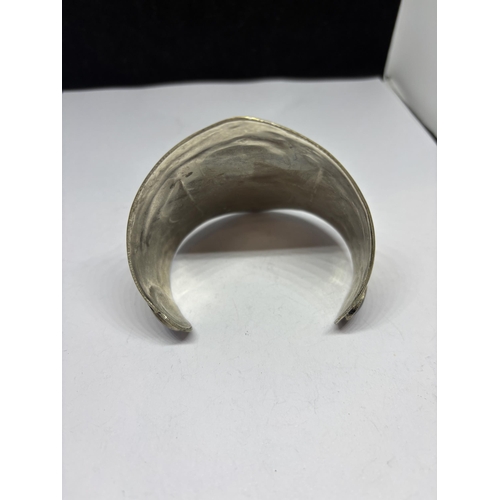 561 - AN ASIAN SILVER BANGLE WITH BLUE STONE DECORATION