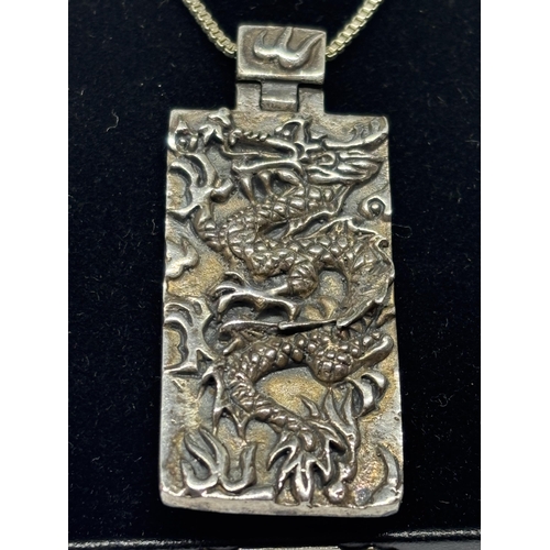 606 - A SILVER CHINESE DRAGON NECKLACE IN A PRESENTATION BOX