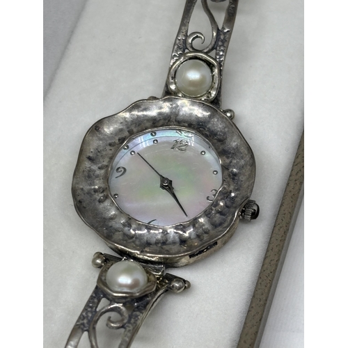 649 - A MARKED SILVER AND MOTHER OF PEARL WATCH IN A PRESENTATION BOX