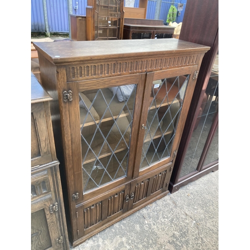 2747 - AN OAK GLAZED AND LEADED TWO DOOR BOOKCASE WITH LINEN FOLD DOORS TO BASE, 38