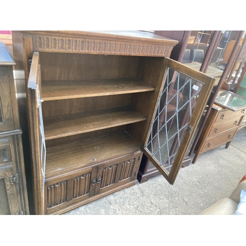 2747 - AN OAK GLAZED AND LEADED TWO DOOR BOOKCASE WITH LINEN FOLD DOORS TO BASE, 38