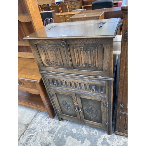 2748 - AN OAK COCKTAIL CABINET WITH LINEN FOLD PANEL, SINGLE DRAWER AND CUPBOARDS TO BASE, 29.5