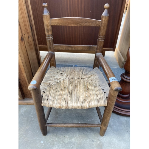 2869 - A CHILDS SIZE OPEN ARM CHAIR WITH RUSH SEAT